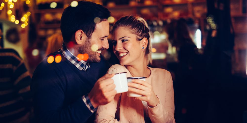 A couple on a date, smiling at each other.